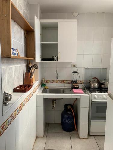 a small kitchen with a sink and a stove at IAN TRAVEL in Cusco