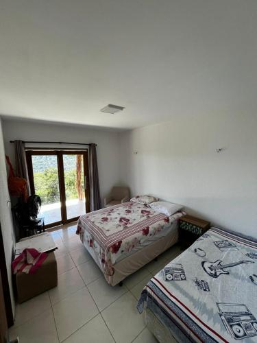 1 Schlafzimmer mit 2 Betten und einem Fenster in der Unterkunft Villa Mazza in Mulungu