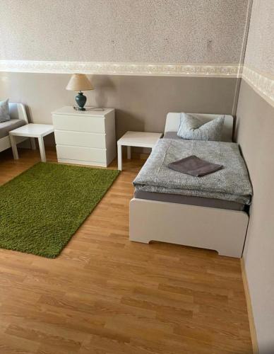 Dormitorio pequeño con cama y alfombra verde en Goethestraße, en Staßfurt