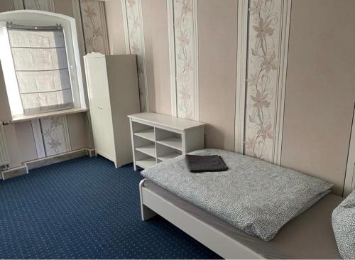 a small room with a bed and a refrigerator at Goethestraße in Staßfurt