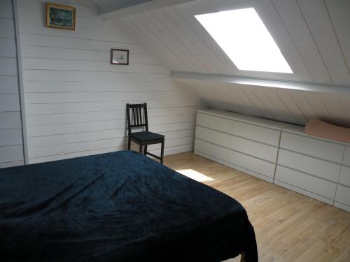 a bedroom with a bed and a chair in a attic at Basilic, 4 pers. Villa Saint Antoine, Orcival, Sancy Auvergne in Orcival