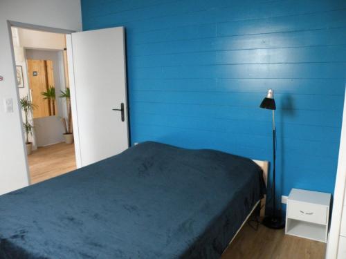 a blue bedroom with a bed and a blue wall at Basilic, 4 pers. Villa Saint Antoine, Orcival, Sancy Auvergne in Orcival
