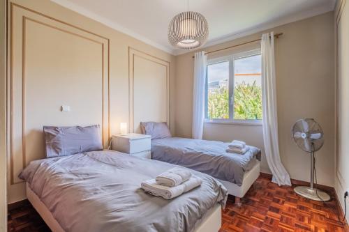 a bedroom with two beds and a window at Sea View in Câmara de Lobos