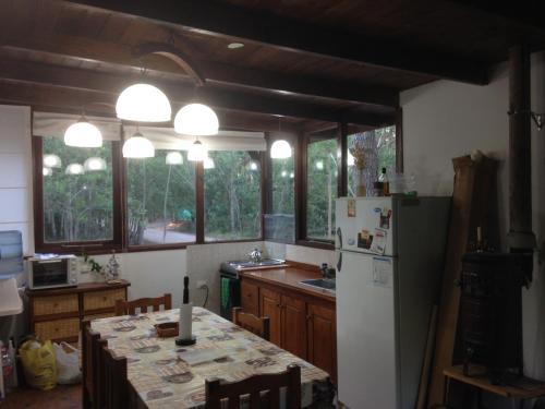 a kitchen with a table and a refrigerator at Complejo Valhalla 6 in Mar Azul