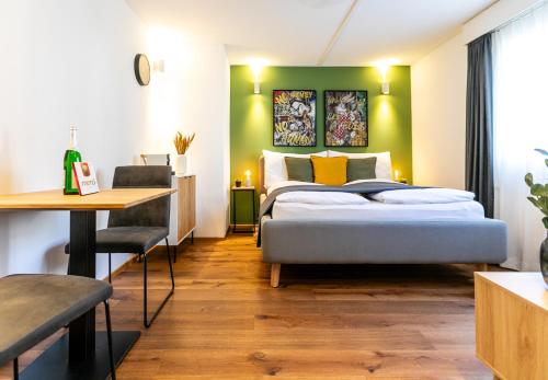 a bedroom with a bed and a table and a desk at Spirit Apartments - Neben dem Titlis - Parkplatz in Engelberg