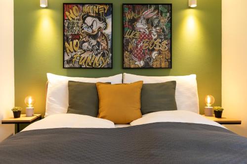 a bedroom with a bed with two paintings on the wall at Spirit Apartments - Neben dem Titlis - Parkplatz in Engelberg