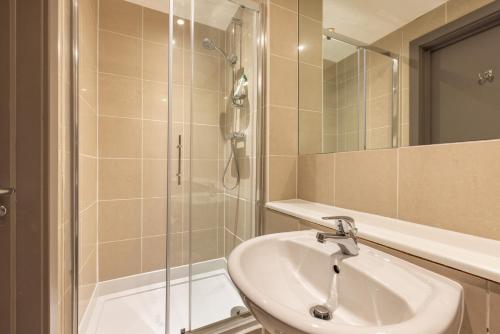 y baño con lavabo y ducha. en Sunshine In My Mood - 2 Bedroom Flat in Battersea, en Londres