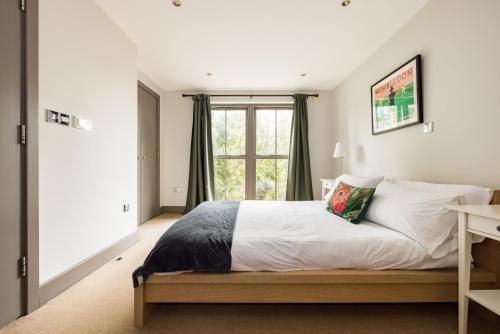 1 dormitorio con cama y ventana en Sunshine In My Mood - 2 Bedroom Flat in Battersea, en Londres