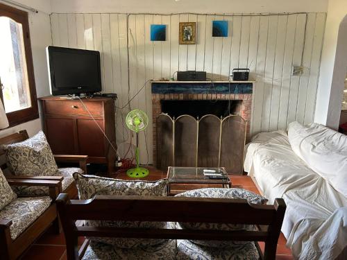 een woonkamer met open haard en tv bij Pancho Villa in Barra de Valizas