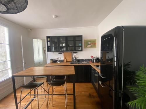 une cuisine avec une table en bois et un réfrigérateur dans l'établissement Aux Terrasses de la Lune, à Paris