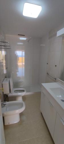 a white bathroom with a toilet and a sink at Sunlivetenerife in Candelaria