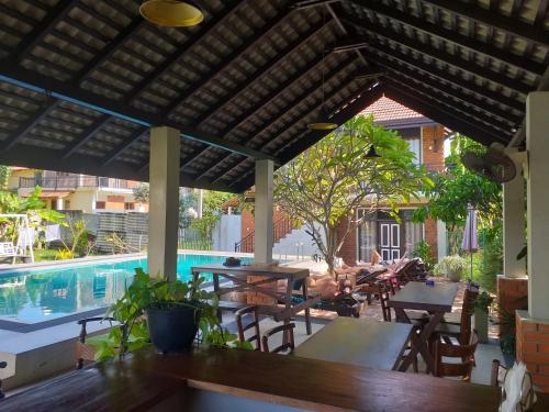 eine Terrasse mit einem Tisch und Stühlen sowie einem Pool in der Unterkunft Green Wood Villa Negombo in Negombo