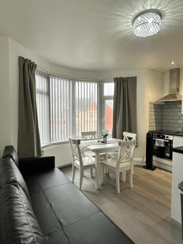 uma cozinha e sala de estar com mesa e cadeiras em Granada Apartments Holmfield Rd em Blackpool