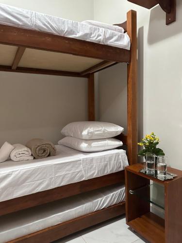 1 dormitorio con 2 literas y mesa en Melhores Flats - Linda casa pertinho do mar en Cabedelo