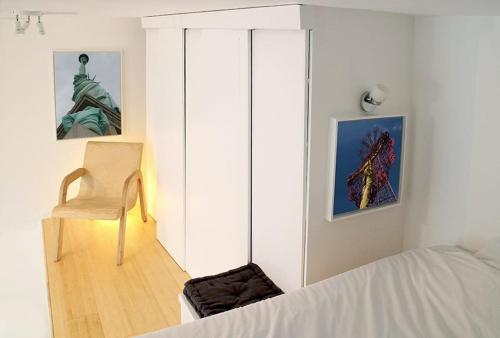 a bedroom with a bed and a chair and a statue at Atelier d'artiste / artist loft / 35m2 in Paris