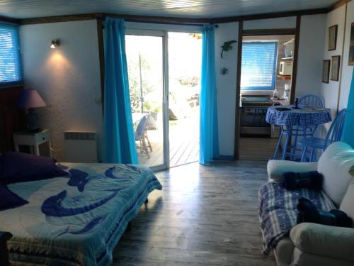 um quarto com uma cama e uma porta de vidro deslizante em L'oiseau BLEU à CALVI em Calvi