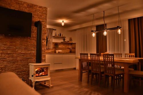 a kitchen and dining room with a wood stove in a room at Villa Šola in Kupres
