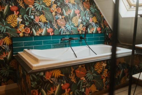 a bathroom with a sink with a floral wallpaper at B&B La Bouliniere in Malmedy