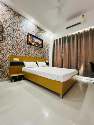 Un dormitorio con una cama grande y una pared en Gaur City Centre en Ghaziabad