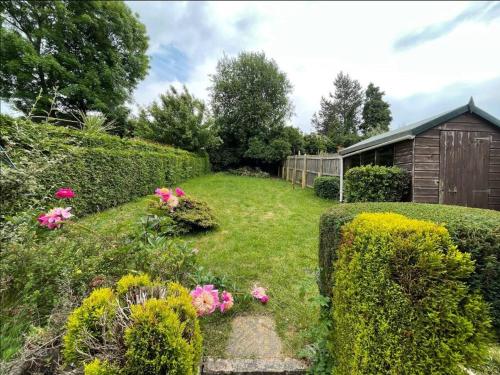 HeeleyにあるModern 3 bedroom home, close to City Centre and Peak Districtのピンクの花と柵のある庭園