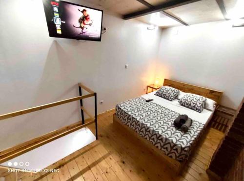 - une chambre avec un lit et une télévision murale dans l'établissement 1 Apartamento duplex con terraza y balcon a 2 calles del metro B8, à Barcelone
