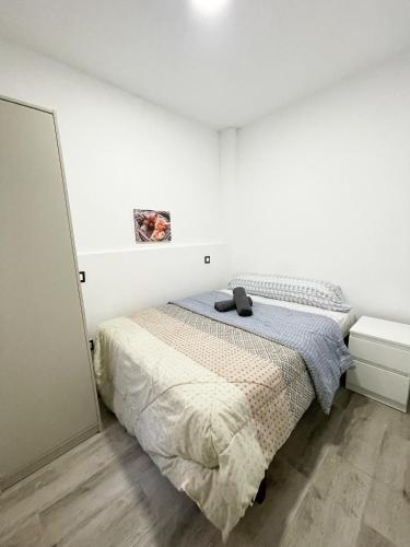 a white bedroom with a bed and a mirror at Apartments near metro in Madrid