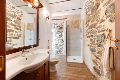 baño con lavabo y pared de piedra en Casa Vacanze Laghi e Monti en Mergozzo