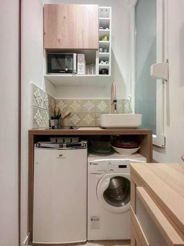 une cuisine avec une machine à laver et un évier dans l'établissement Charming Studio in the center of Paris, à Paris