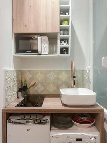une petite cuisine avec un évier et un micro-ondes dans l'établissement Charming Studio in the center of Paris, à Paris