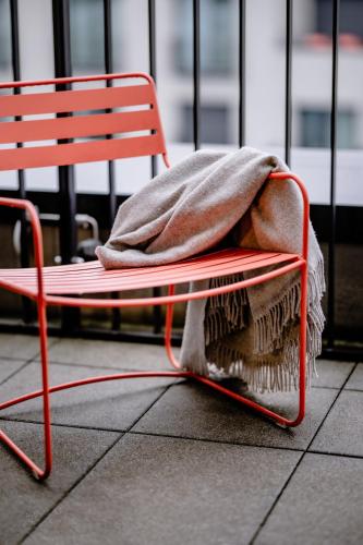 a red bench with a blanket on top of it at THE FLAG München M. in Munich