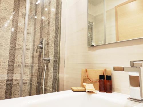 uma casa de banho com um chuveiro e um lavatório. em Luxury Suites - Stay Inn Rome Experience em Roma