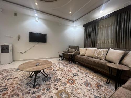 a living room with a couch and a tv at 8 Luxury housing شقة فاخر in Al ‘Awālī