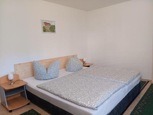 a bedroom with a bed with blue and white pillows at Ferienwohnung Füssel am Malerweg in Schöna