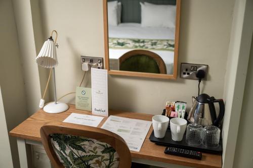 a desk with a mirror and a bed in a room at Rockingham Arms By Greene King Inns in Wentworth