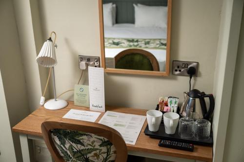 a desk with a mirror and a bed in a room at Rockingham Arms By Greene King Inns in Wentworth