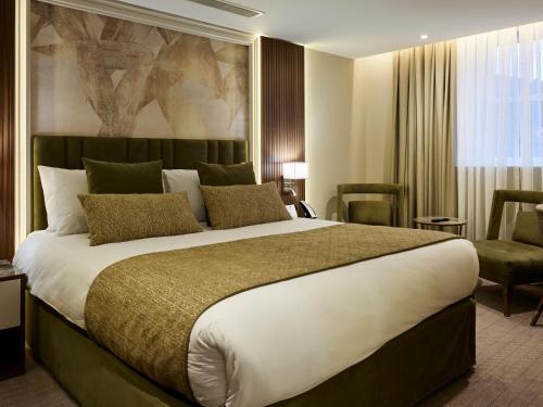 a hotel room with a large bed and a chair at Dover Marina Hotel & Spa, Tapestry Collection by Hilton in Dover