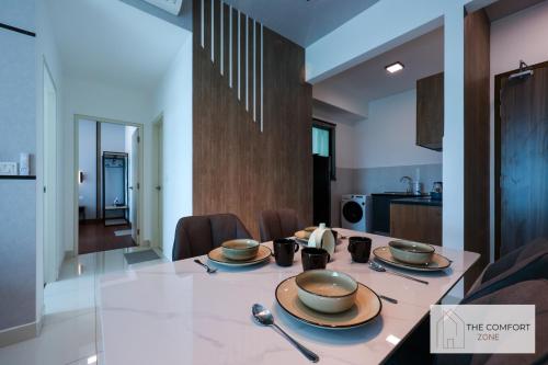 a dining room with a table with bowls on it at Greenfield Residence, Bandar Sunway by The Comfort Zone in Petaling Jaya