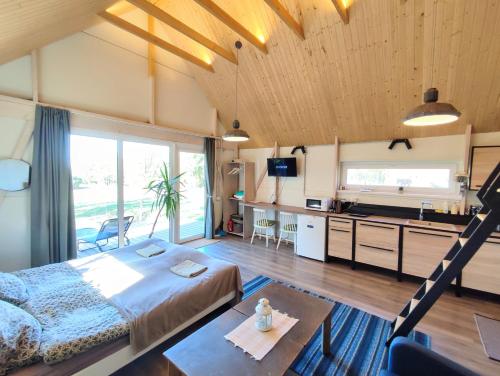 a bedroom with a bed and a desk and a kitchen at Modern Sauna Cabin in Horse Ranch in Lieplaukė