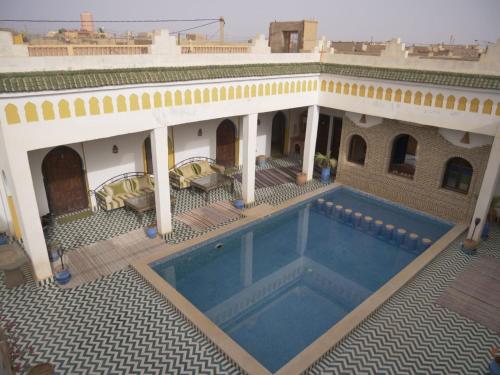 an external view of a building with a swimming pool at Casa Laman in Merzouga