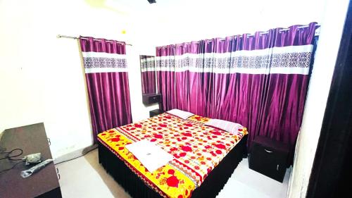 プリーにあるGoroomgo New Sriyansh Puriのベッドルーム1室(紫色のカーテン付きのベッド1台付)