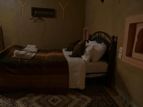 a bedroom with a bed with pillows on it at Casa laman in Merzouga