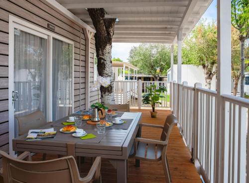 a porch with a table and chairs on a deck at Club del Sole Tenuta Primero Grado Family Collection in Grado