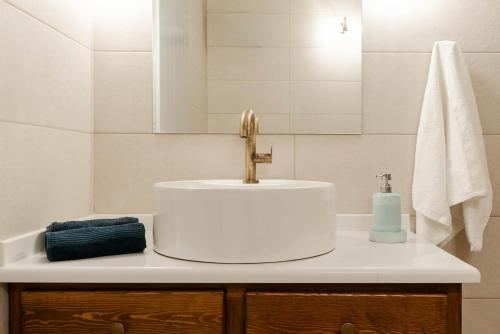 a bathroom with a white sink and a mirror at Green Mountain Seaview Suite in Achílleion