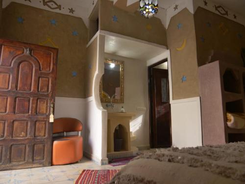 a bedroom with a bed and a door with stars on the wall at Casa Laman in Merzouga