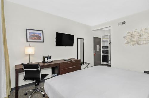a hotel room with a bed and a desk and a television at Ohio House Motel in Chicago