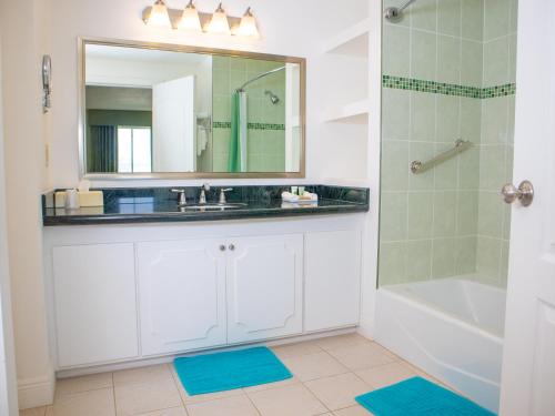 a bathroom with a sink and a shower with a mirror at Princess Vegas Hotel & Casino in Corozal