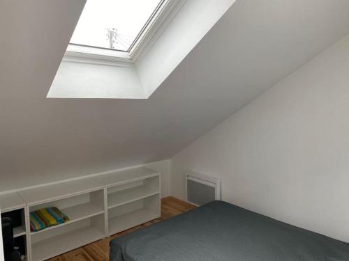 une chambre blanche avec un lit et une fenêtre dans l'établissement Agréable maison à Arcachon, à Arcachon