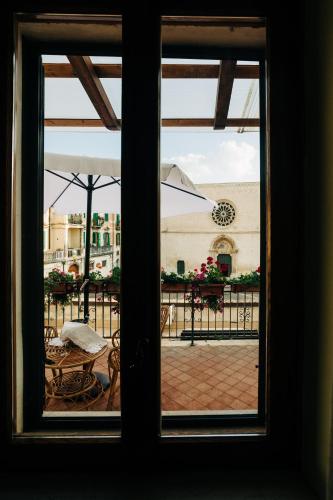 a window view of a patio with an umbrella at Appartamento Venere e Adone in Sulmona