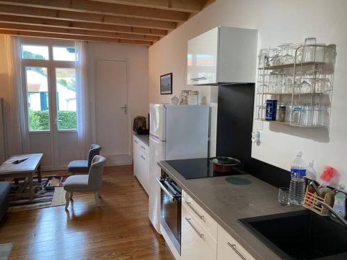une cuisine avec un réfrigérateur blanc et une table dans l'établissement Agréable maison à Arcachon, à Arcachon