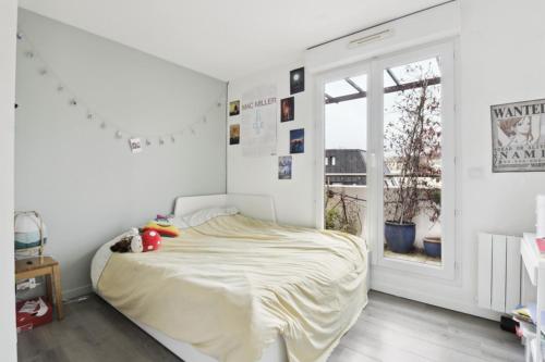 a white bedroom with a bed and a window at L'Eden Urbain - Issy-les-Moulineaux in Issy-les-Moulineaux